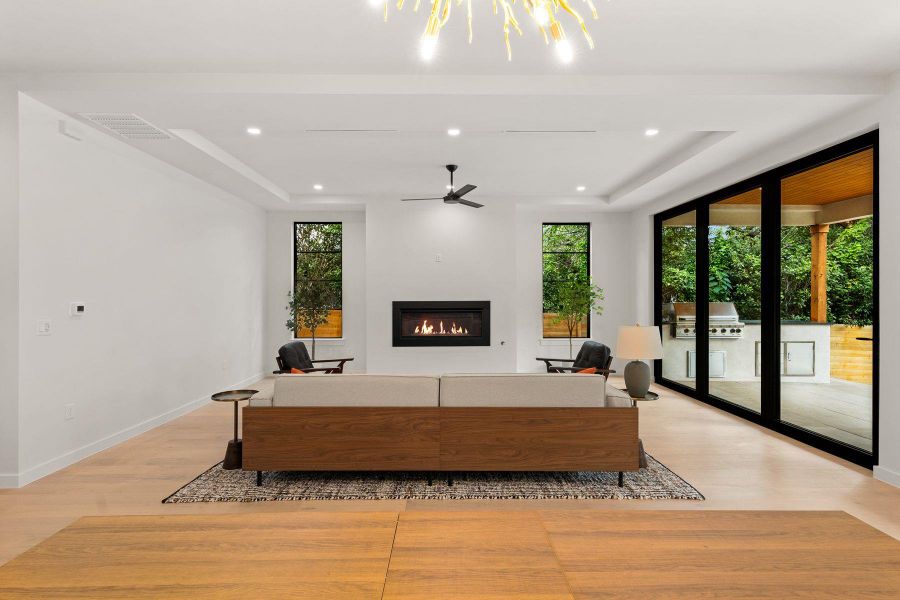 Floor-to-ceiling sliding glass doors frame verdant backyard views in this modern, airy living space.