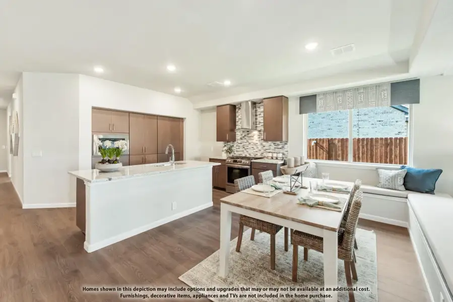 Open-concept kitchen and dining area with dark wood cabinets, large island, and breakfast nook seating
