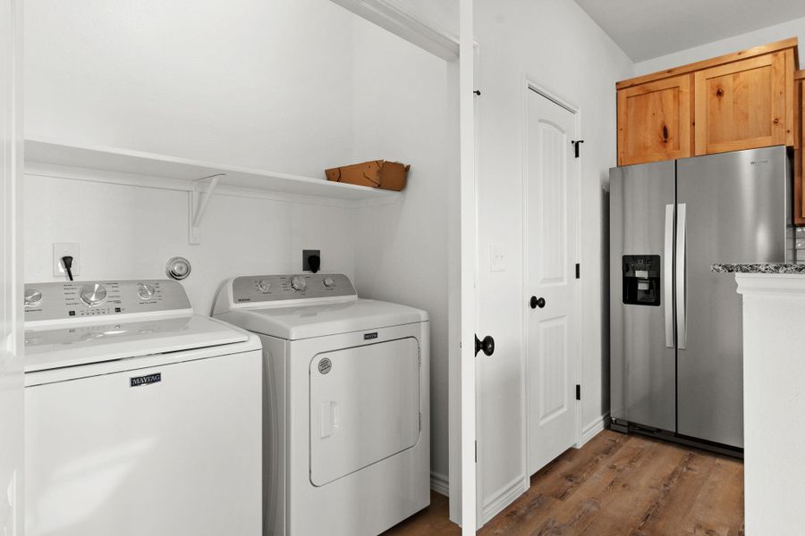 Laundry room with wood finished floors, separate washer and dryer, and laundry area Laundry room with wood finished floors, separate washer and dryer, and laundry area