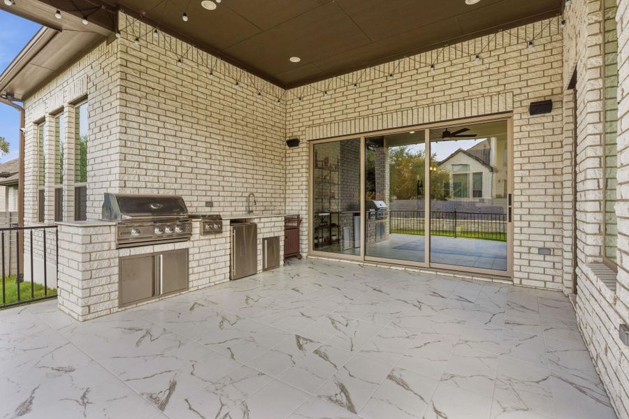 An inviting outdoor kitchen on a patio offers a built-in grill, sink, and storage. An inviting outdoor kitchen on a patio offers a built-in grill, sink, and storage.