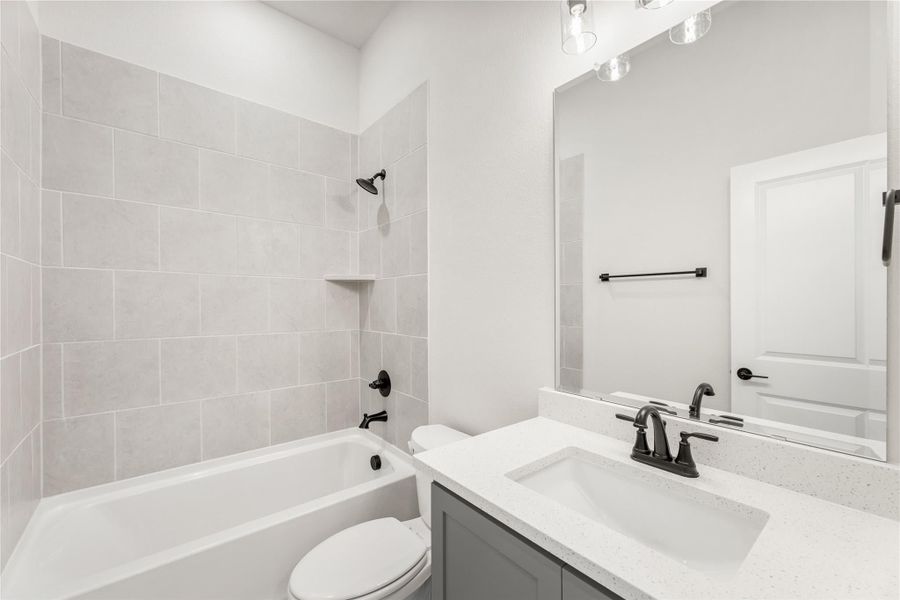 Bathroom with tiled tub-shower combo, single vanity with quartz countertop, and matte black fixtures Bathroom with tiled tub-shower combo, single vanity with quartz countertop, and matte black fixtures