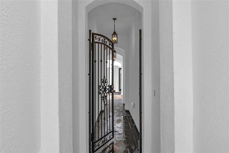 Walk through the wrought iron gate through the arched corridor. Walk through the wrought iron gate through the arched corridor.