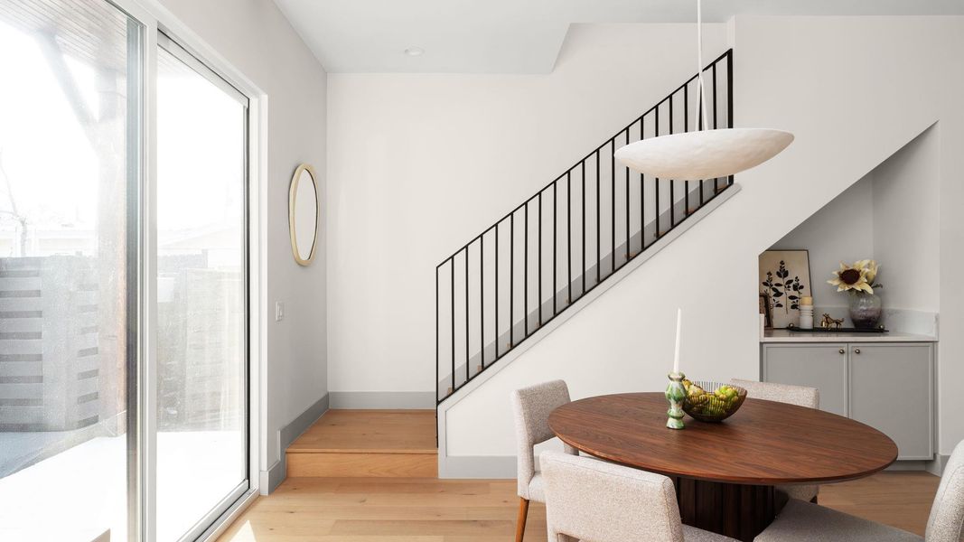 Dining room with healthy amount of natural light, light wood-style floors, and stairs