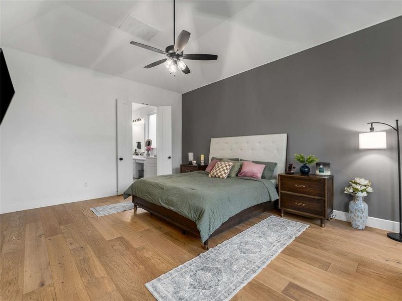 Primary bedroom with vaulted ceiling and an ensuite bathroom