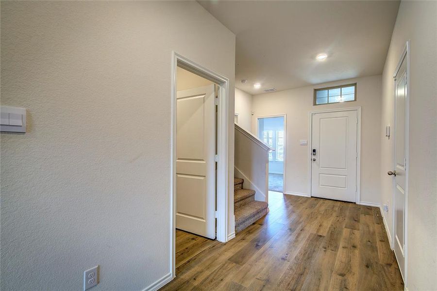 Foyer featuring stairway and wood finished floors