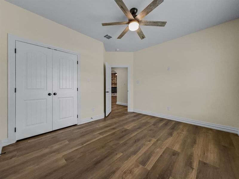 Unfurnished bedroom featuring wood finished floors, a closet, and ceiling fan Unfurnished bedroom featuring wood finished floors, a closet, and ceiling fan
