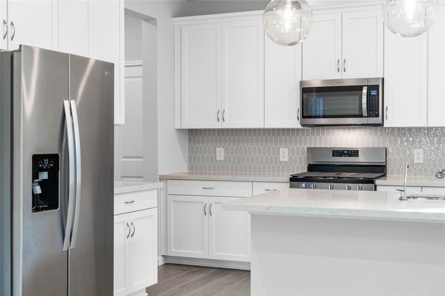 Kitchen comes equipped with a side-by-side Whirlpool refrigerator.