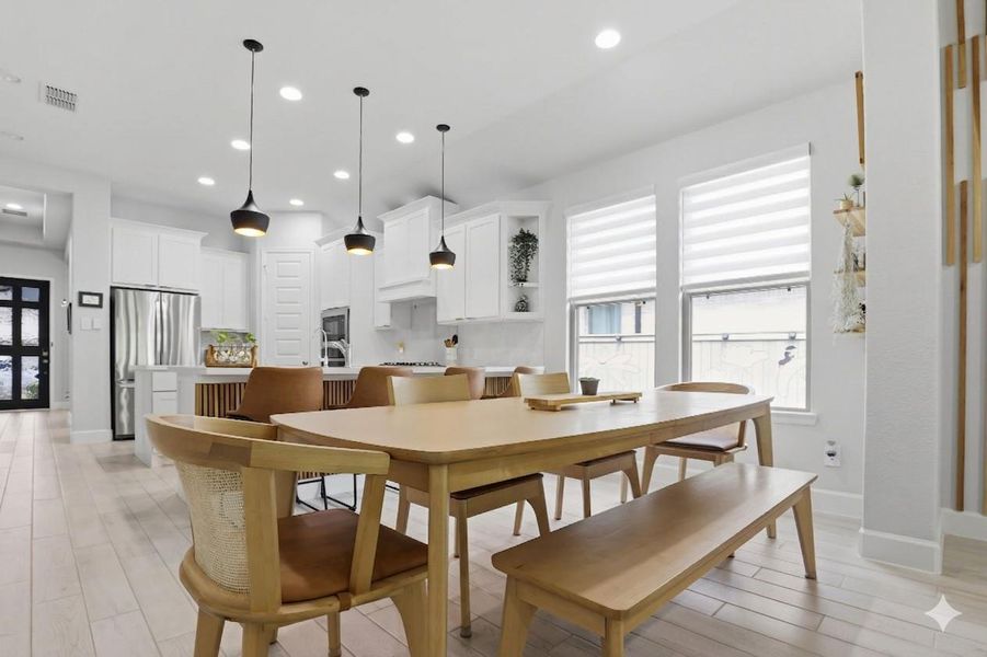 Located between the kitchen and living room, the dining space is anchored by modern pendant lighting and natural light.