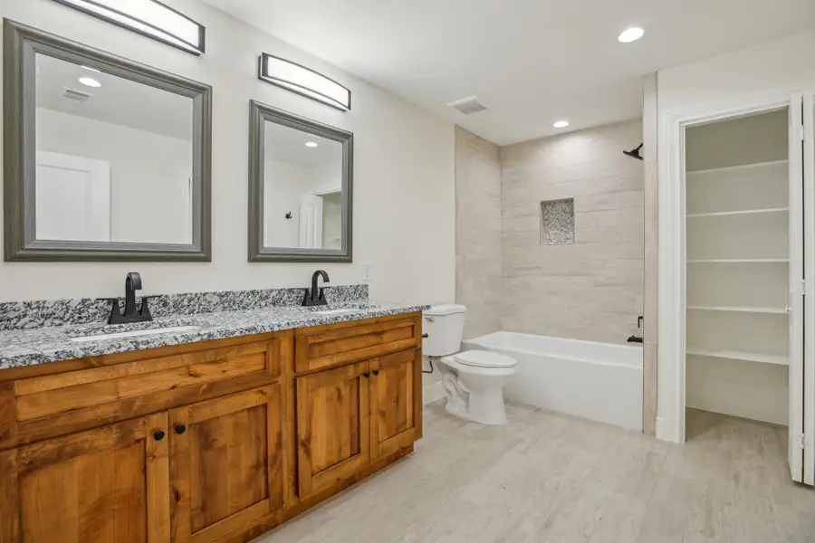 Jack and Jill Bathroom with wood tile floors, a sink, and visible vents