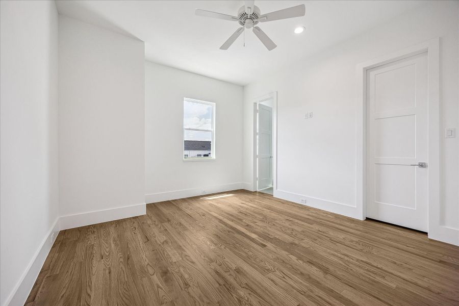 Spacious secondary bedroom filled with natural light and hardwoods continued.