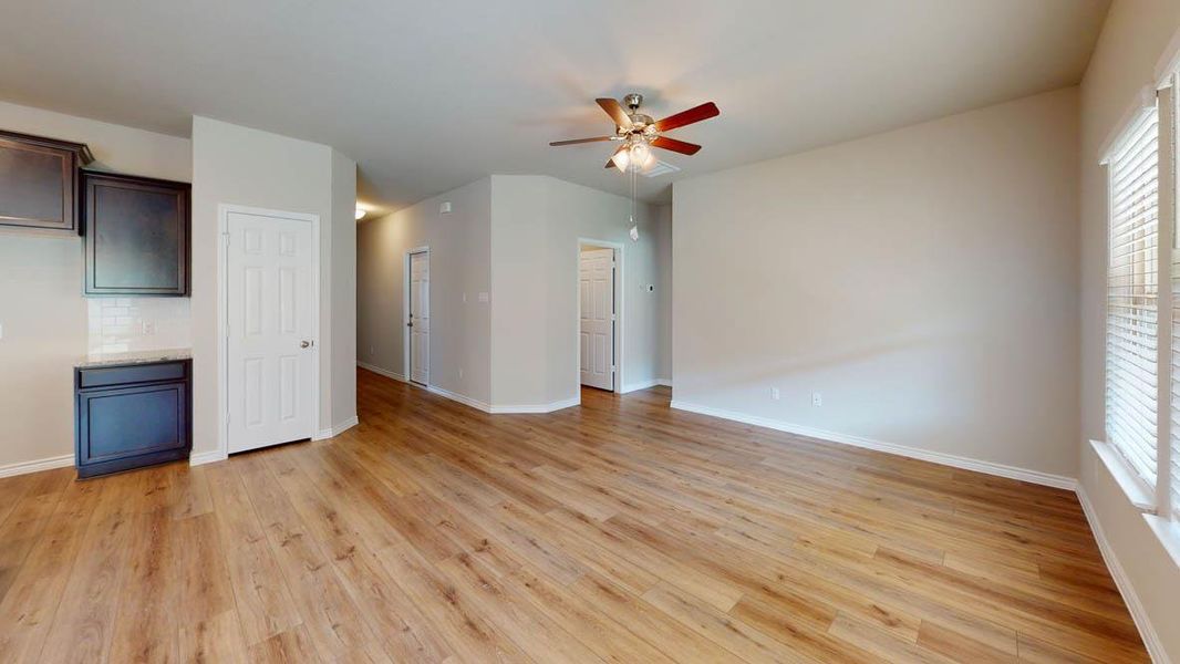 Unfurnished living room with a ceiling fan and light wood-style flooring