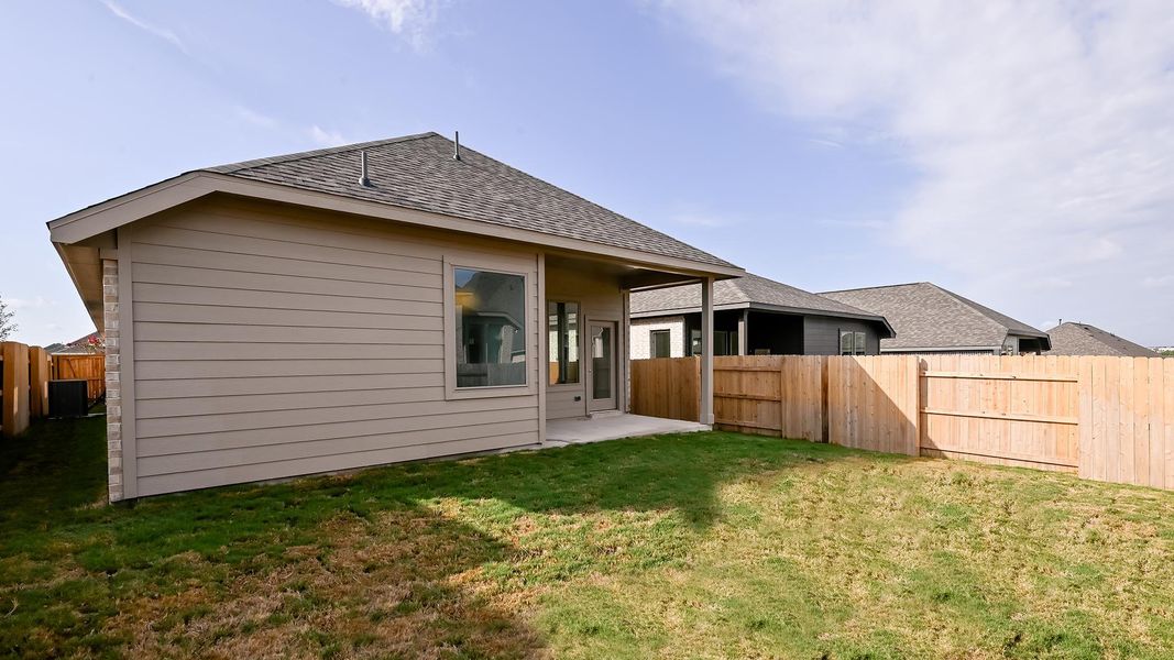 Back of house featuring a patio, a fenced backyard, and roof with shingles