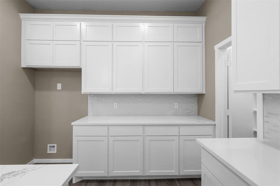 Kitchen with white cabinetry and decorative backsplash