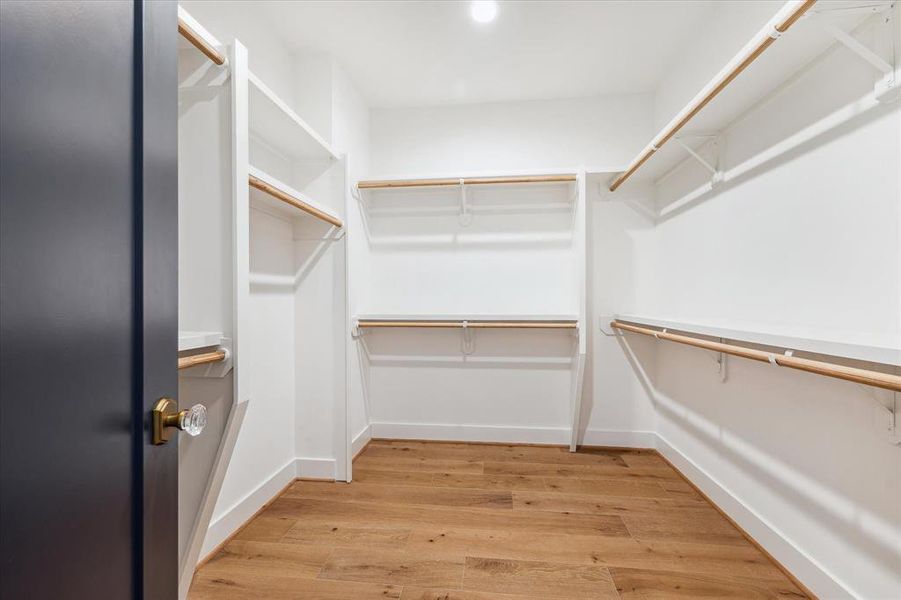 Spacious primary closet allowing for a plethora of clothes and storage.