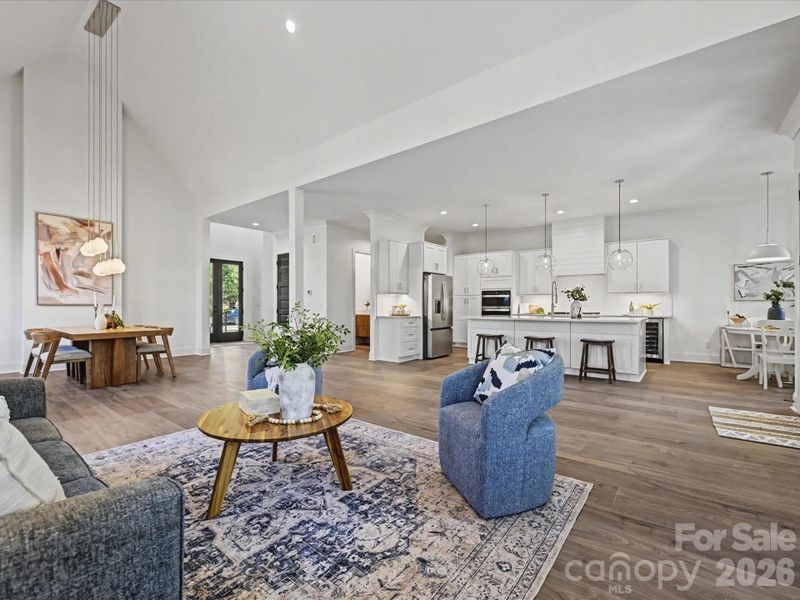 Spacious great room featuring soaring ceilings, abundant natural light, and an open layout that creates an inviting space for relaxing and entertaining.