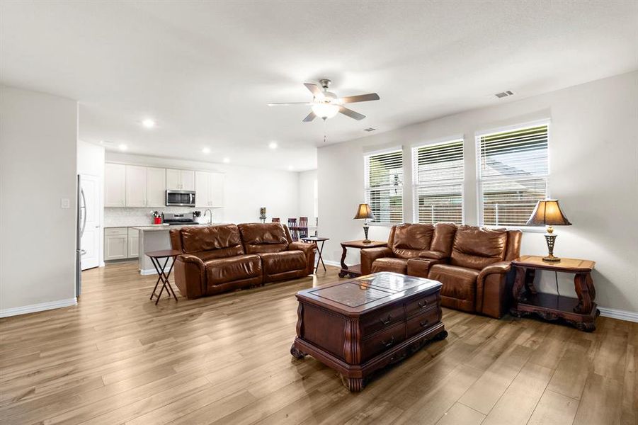Living area with ceiling fan, light wood-style floors, and recessed lighting Living area with ceiling fan, light wood-style floors, and recessed lighting