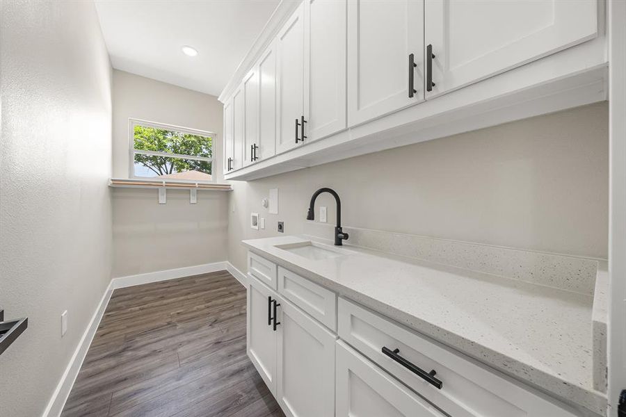 Laundry area with electric dryer hookup, hookup for a washing machine, cabinet space, dark wood-style flooring, and recessed lighting Laundry area with electric dryer hookup, hookup for a washing machine, cabinet space, dark wood-style flooring, and recessed lighting