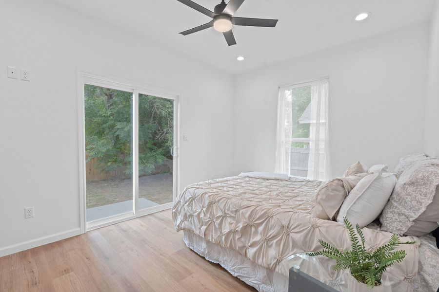 Bedroom featuring access to exterior, light wood-style flooring, recessed lighting, and ceiling fan