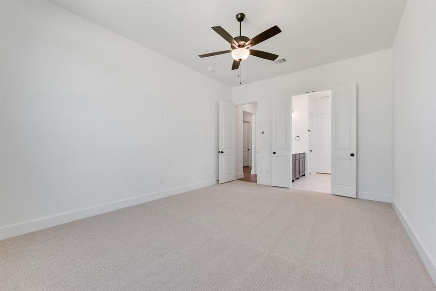 Unfurnished bedroom featuring light carpet, ceiling fan, and ensuite bathroom Unfurnished bedroom featuring light carpet, ceiling fan, and ensuite bathroom