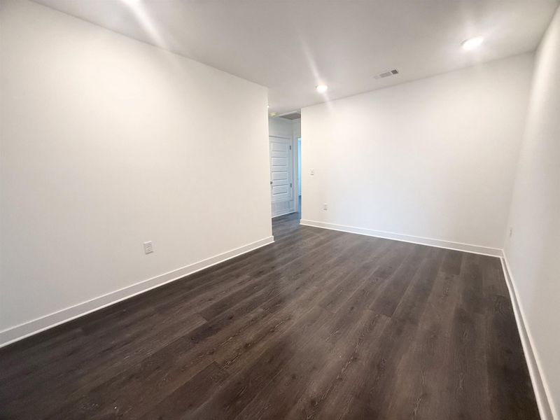 Unfurnished room with dark wood-style floors and recessed lighting