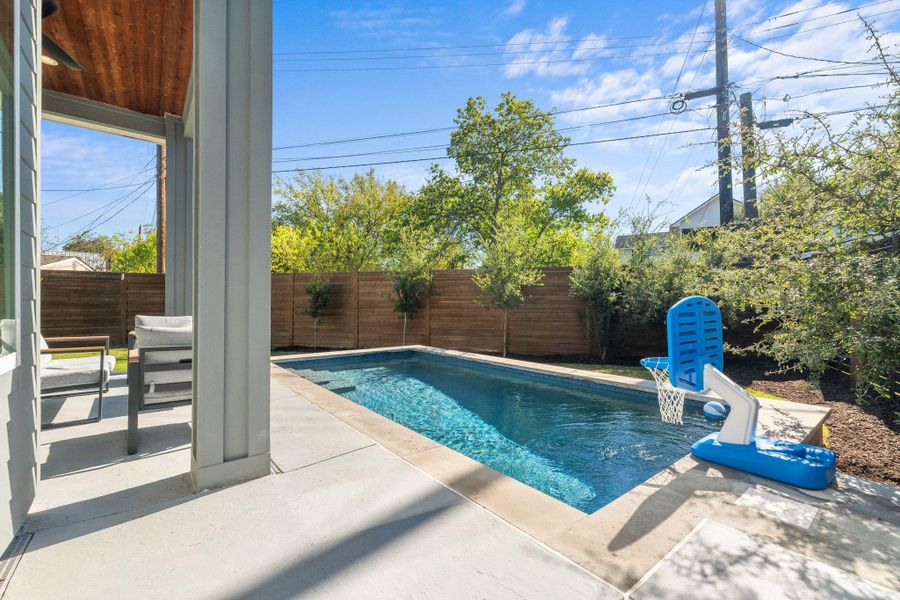 View of swimming pool with a patio and a fenced backyard
