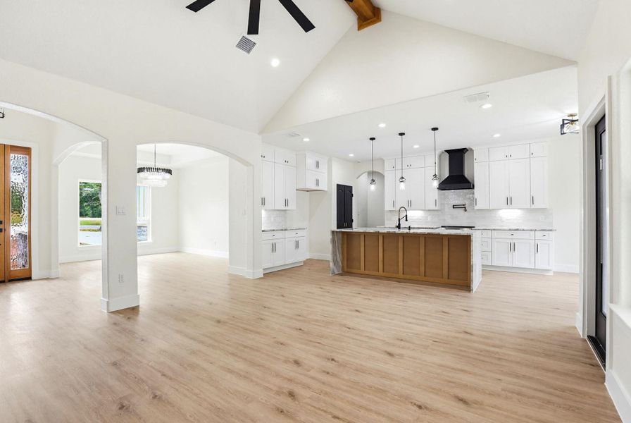 An open-concept living area with vaulted ceilings and a modern kitchen island creates a spacious feel.