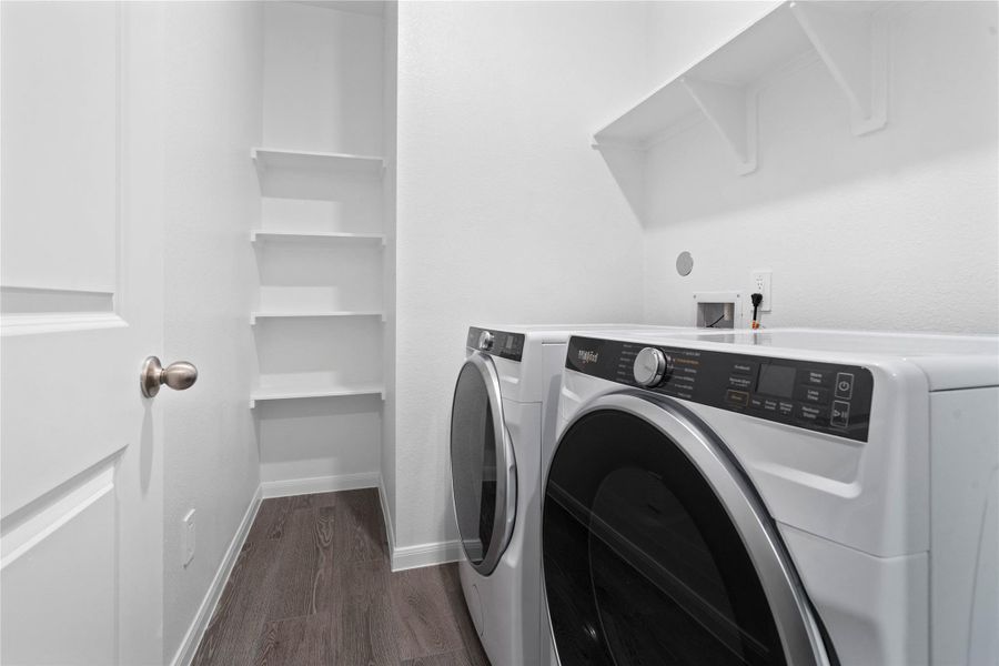 This dedicated laundry room comes equipped with a washer and dryer set, ready for immediate use.