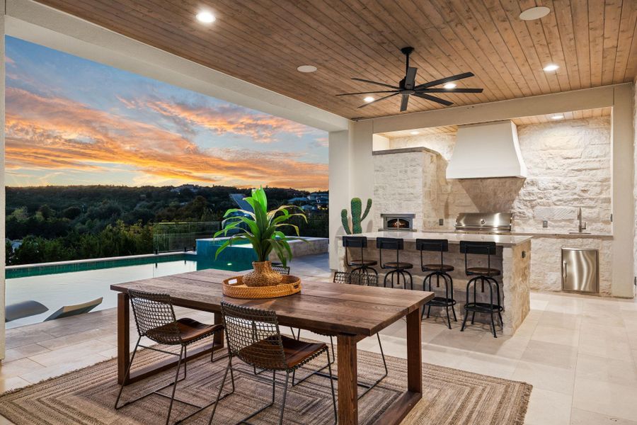 View of patio featuring exterior kitchen, ceiling fan, outdoor dining area, and an outdoor pool View of patio featuring exterior kitchen, ceiling fan, outdoor dining area, and an outdoor pool