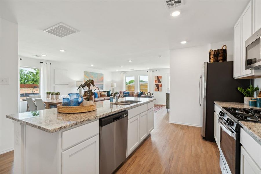 Kitchen featuring sink, white cabinets, light hardwood / wood-style floors, and appliances with stainless steel finishes