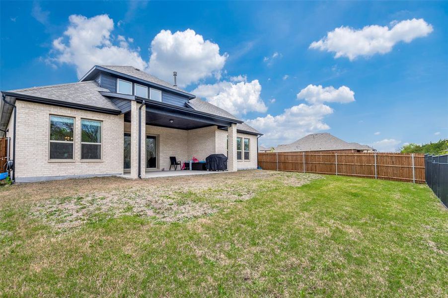 Back of house with a patio area and a yard