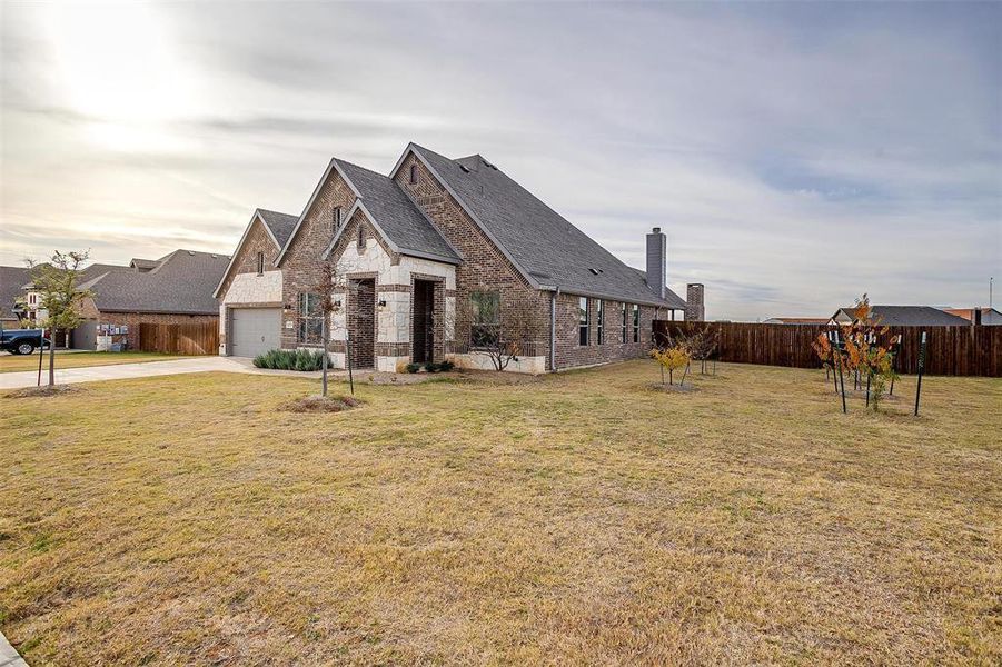 View of front of house with a garage and a front lawn