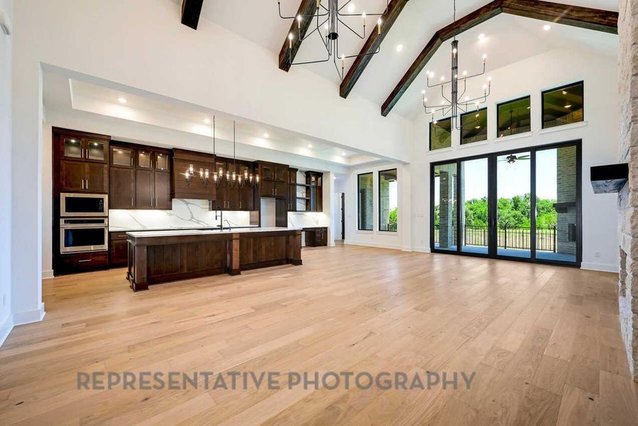 Kitchen with a chandelier, dark brown cabinetry, glass insert cabinets, light wood-style flooring, and light countertops Kitchen with a chandelier, dark brown cabinetry, glass insert cabinets, light wood-style flooring, and light countertops
