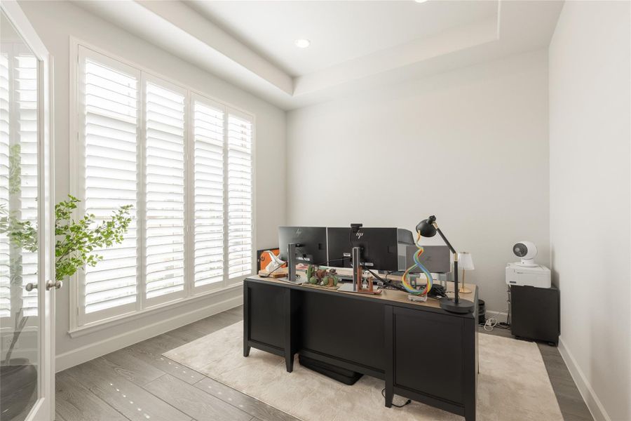 Home office with large windows and custom plantation shutters. Home office with large windows and custom plantation shutters.
