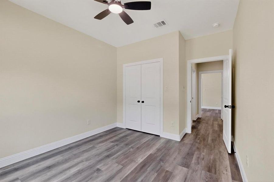 Unfurnished bedroom with wood finished floors, ceiling fan, and a closet Unfurnished bedroom with wood finished floors, ceiling fan, and a closet