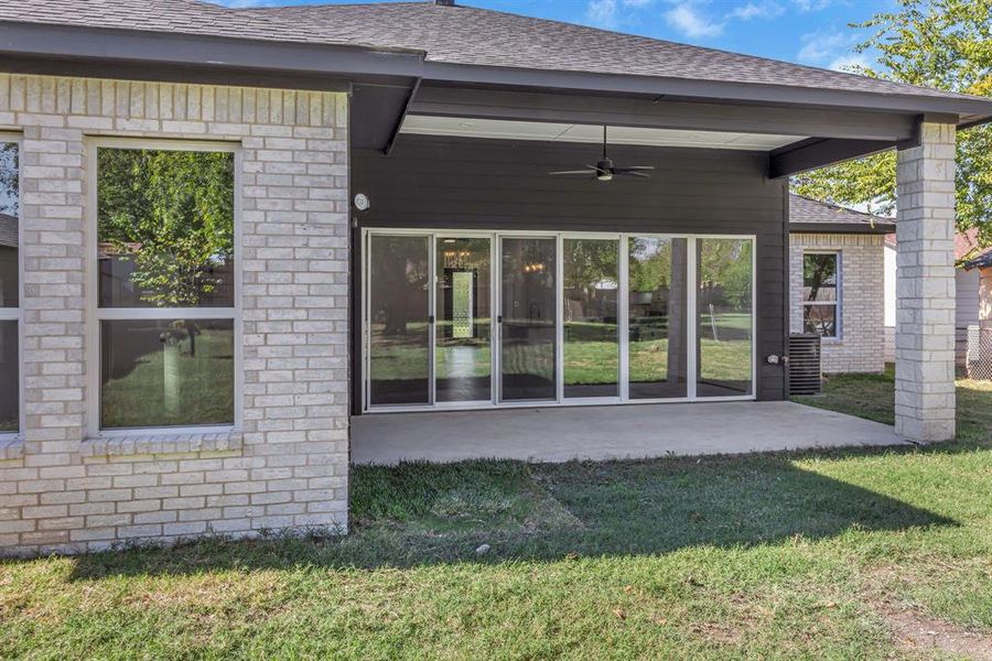 Back of house featuring a patio area, a lawn, and ceiling fan