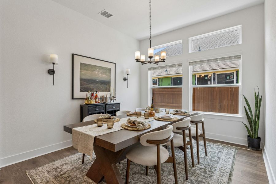High ceilings and tall windows elevate this inviting dining space with wood floors.