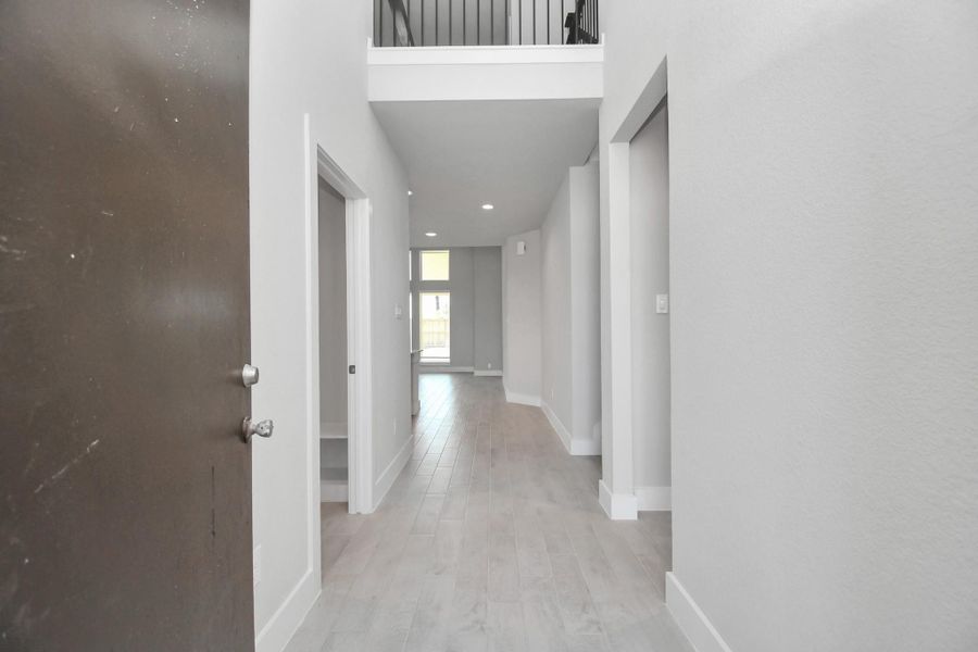 As you step into the threshold of this luxurious home, you'll soon be welcomed by an elegant glass door (to be installed). Inside, soaring ceilings amplify the spaciousness, while the refined wood-look tile flooring and oversized baseboards exude sophistication and charm. Sample photo of completed home with similar floor plan. Actual colors and selections may vary.