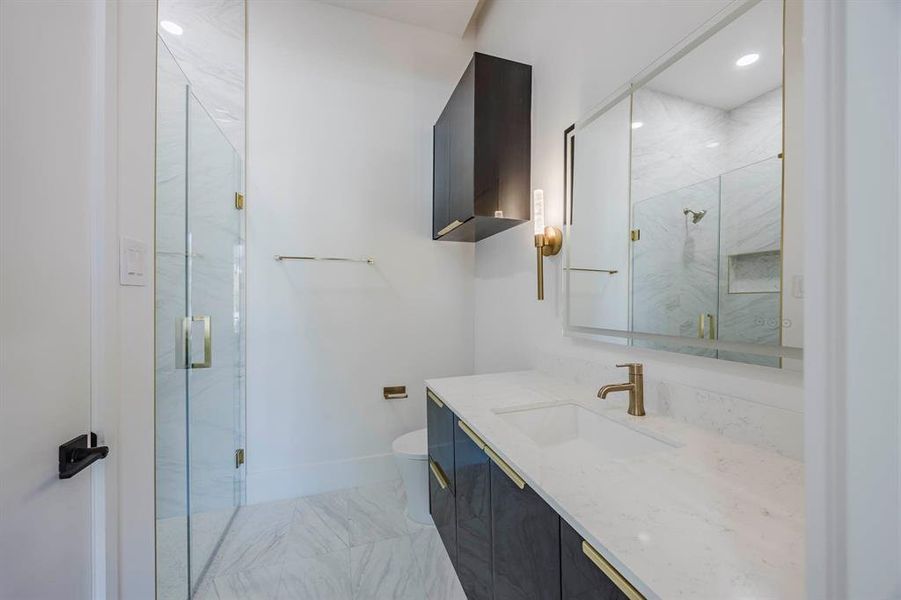 Full bathroom featuring a marble finish shower, vanity, and light marble finish floors Full bathroom featuring a marble finish shower, vanity, and light marble finish floors