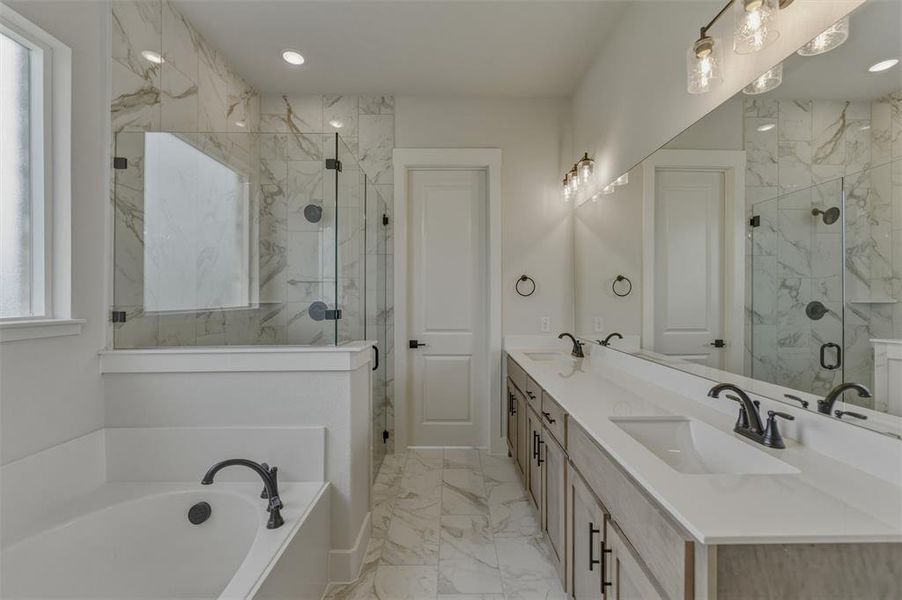 Contemporary bathroom featuring a spacious built-in tub, a walk-in shower with clear glass enclosure and marble-look tile surround, a dual vanity with undermount sinks, and an expansive mirror Contemporary bathroom featuring a spacious built-in tub, a walk-in shower with clear glass enclosure and marble-look tile surround, a dual vanity with undermount sinks, and an expansive mirror