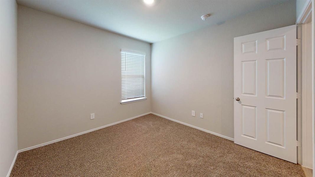 Carpeted spare room featuring baseboards