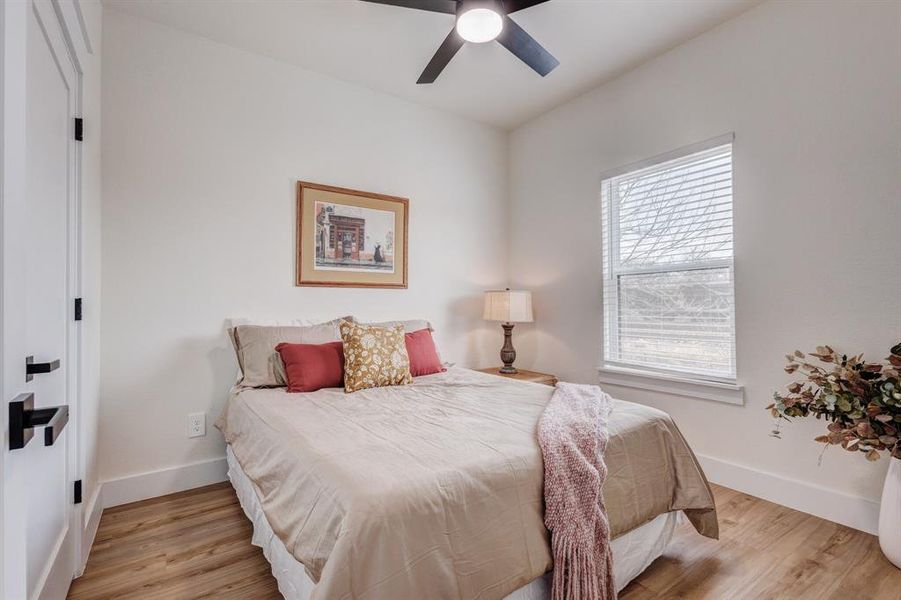 Bedroom with ceiling fan and light hardwood / wood-style flooring Bedroom with ceiling fan and light hardwood / wood-style flooring