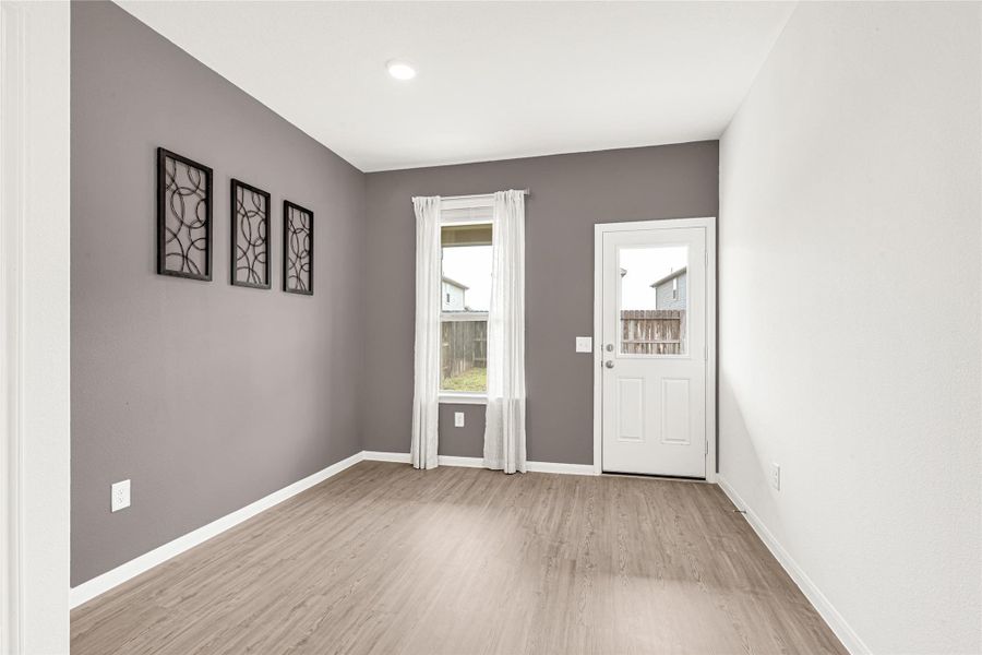 Additional look at a versatile room with a dark multi-paneled accent wall and clean flooring.