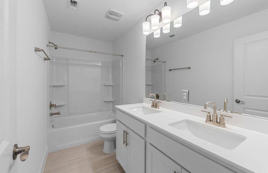 Full bathroom with double vanity and shower / bath combination