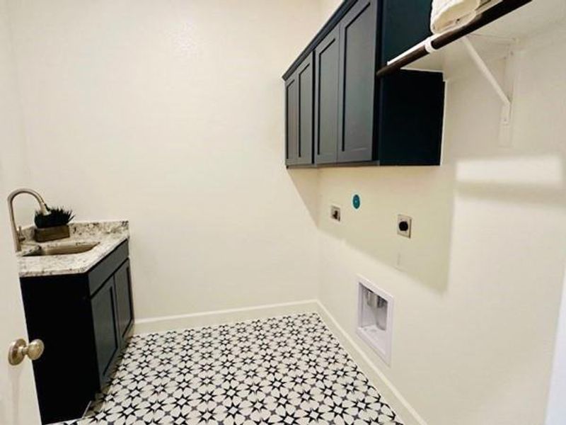 Large utility room plumbed for gas or electric dryer, upper cabinets and sink!