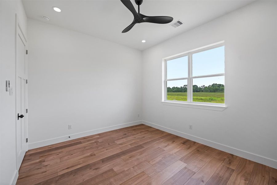 This inviting third bedroom features sleek hardwood floors, ample natural light, and a convenient Jack & Jill bathroom, perfect for guests or family.