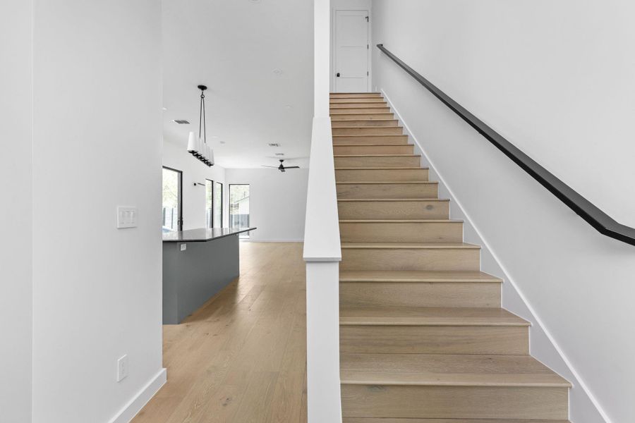 Stairway featuring wood finished floors and a ceiling fan