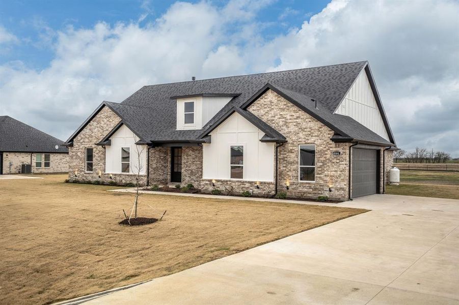 View of front of house featuring a front yard and a garage