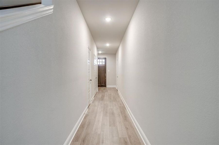 Corridor with light wood finished floors and baseboards