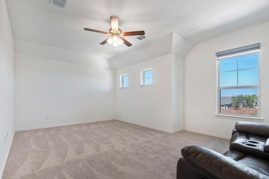 Unfurnished room with light colored carpet, a ceiling fan, and lofted ceiling Unfurnished room with light colored carpet, a ceiling fan, and lofted ceiling