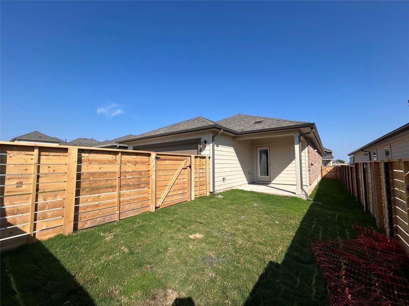 Rear view of house featuring a patio area, a fenced backyard, roof with shingles, and brick siding Rear view of house featuring a patio area, a fenced backyard, roof with shingles, and brick siding